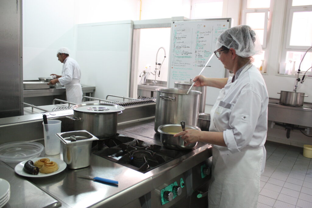 Cathy la cuisinière, et Gilbert au fond, sert des soupières de mouliné de légumes pour le service à table © Récit en Série - Isabelle Desprez.