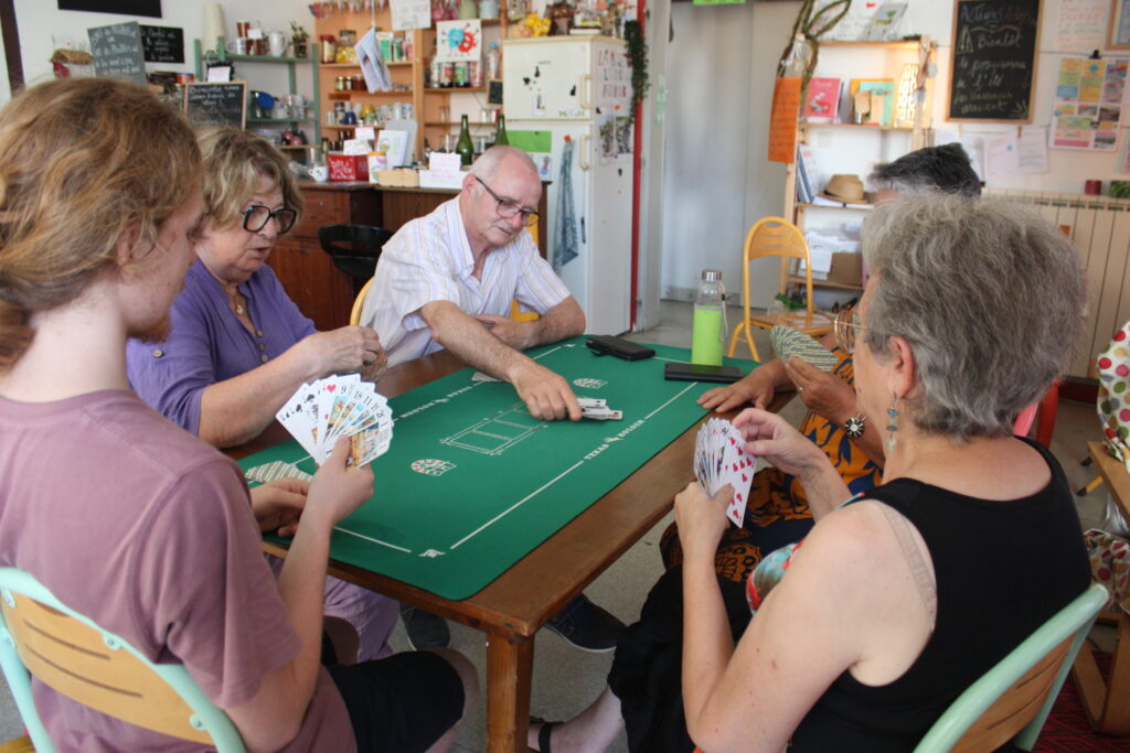 Au rez-de-chaussée de la maison partagée de la MJC, douze aficionados du tarots tapent le carton par équipe © Récit en Série - Isabelle Desprez.