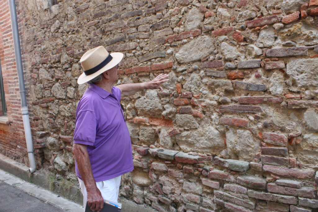 André Tandou montre un pan de mur de l'ancien château L'Islois rue d'Ansan © Récit en Série - Isabelle Desprez.