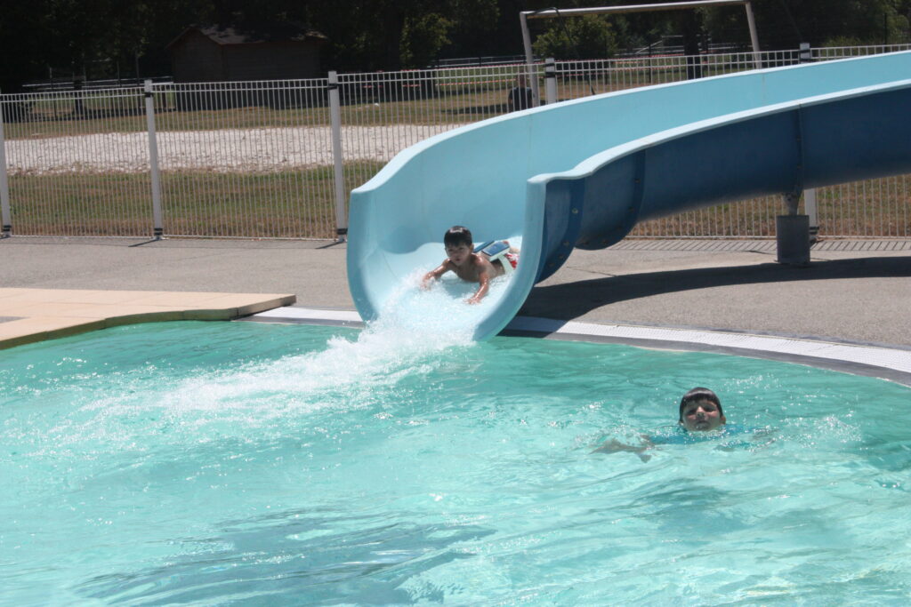 Les enfants s'amusent au toboggan de la piscine municipale de L'Isle-en-Dodon © Récit en Série - Isabelle Desprez.