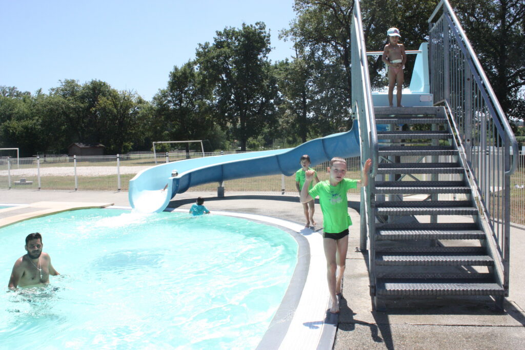 Les enfants s'amusent au toboggan de la piscine municipale de L'Isle-en-Dodon © Récit en Série - Isabelle Desprez.