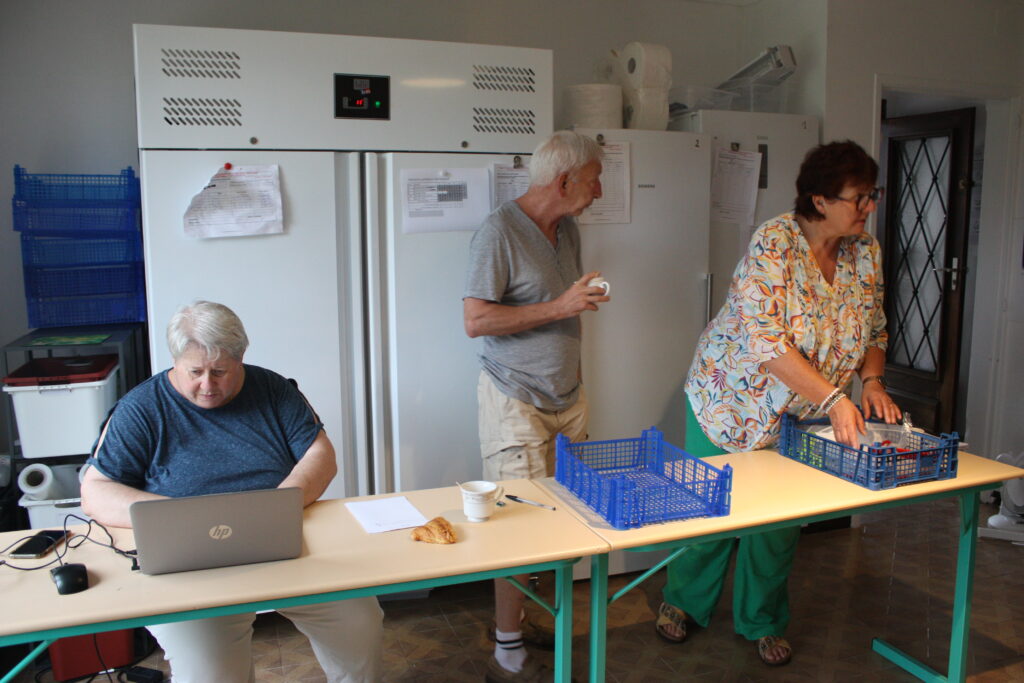 Michel, bénévole aux surgelés et laitages, entouré des deux Sylviane co-responsables de l'antenne de L'Isloise des Restos du Cœur © Récit en Série - Isabelle Desprez.